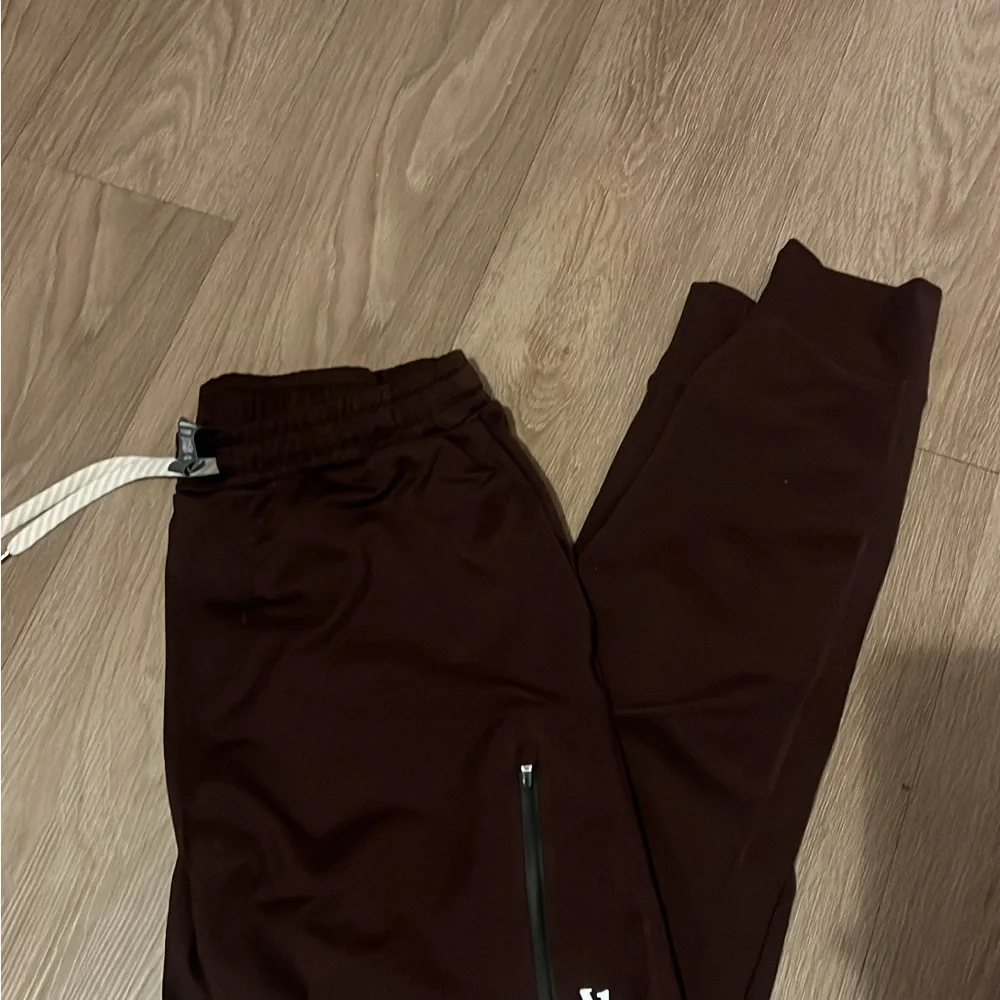 Vuori Men's Sunday Performance Joggers in a brown/oxblood color. - Picture 1 of 5